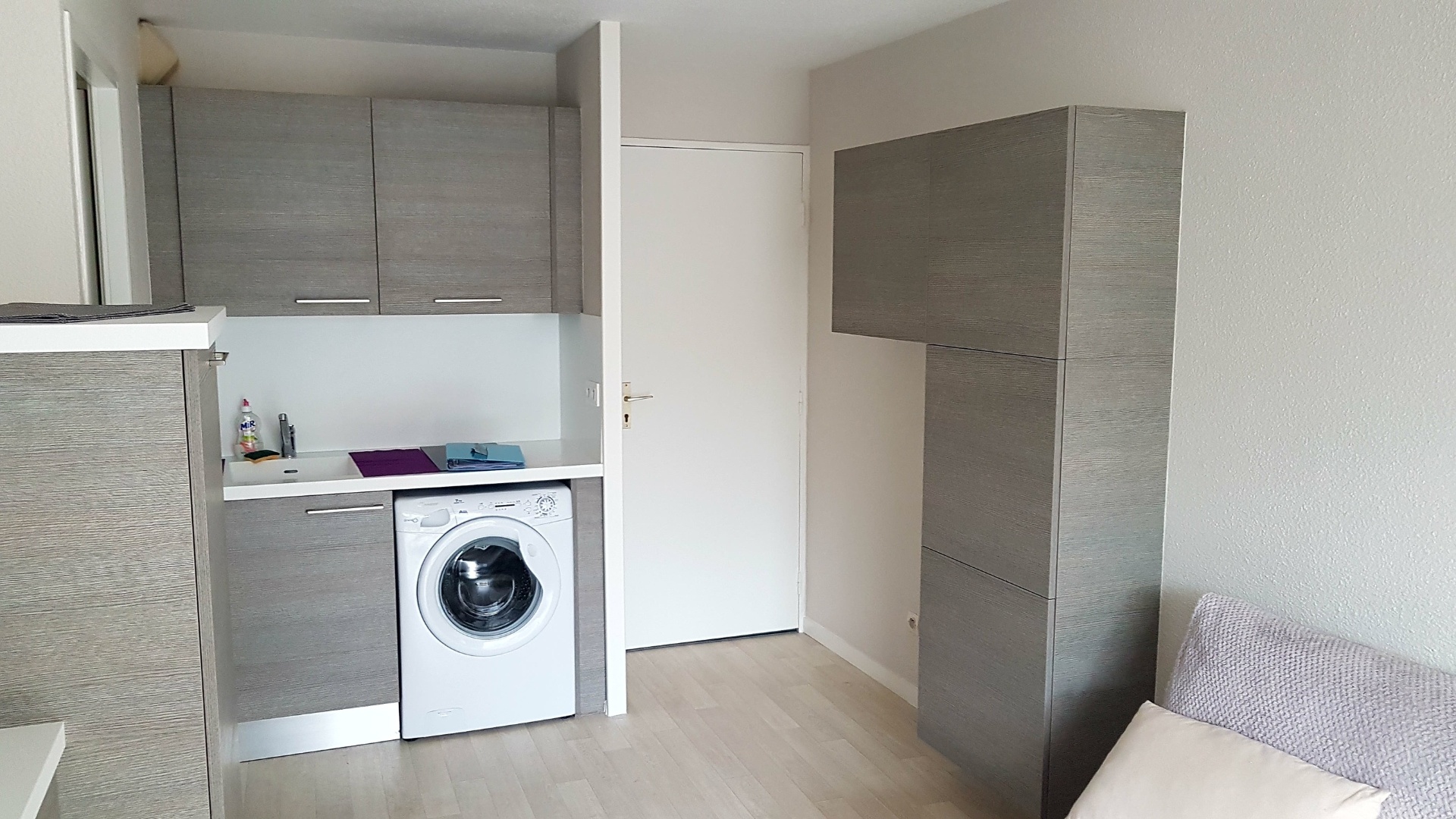 Coin buanderie compact, façades grises et plan blanc