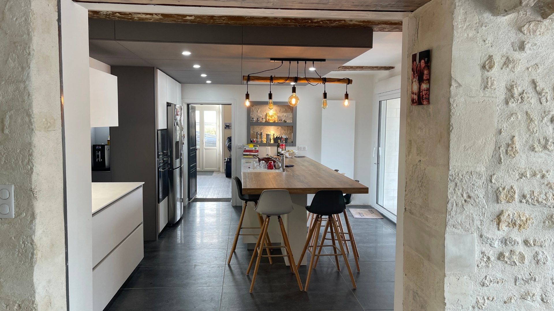 Cuisine pierre apparente, îlot bois et finitions anthracite